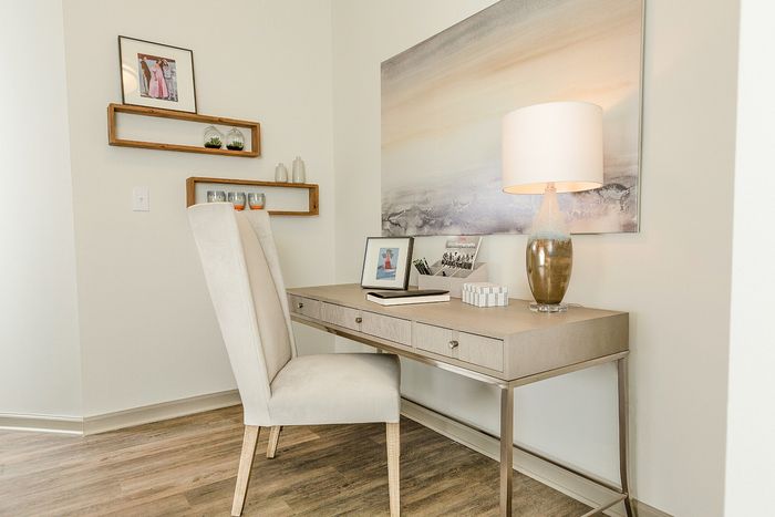 Chic home office with elegant desk, stylish chair, and ambient lighting, complemented by modern wall art and decorative shelving.