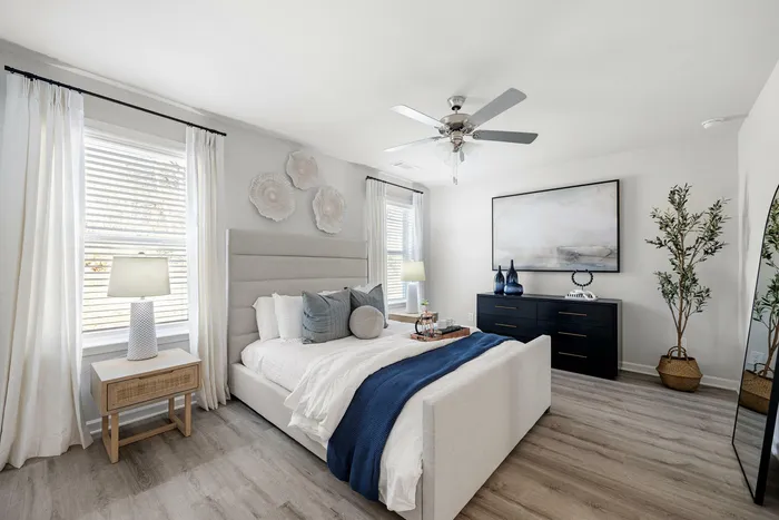 Bright, elegant bedroom with a chic upholstered bed, stylish decor, and natural light accentuating a serene ambiance.