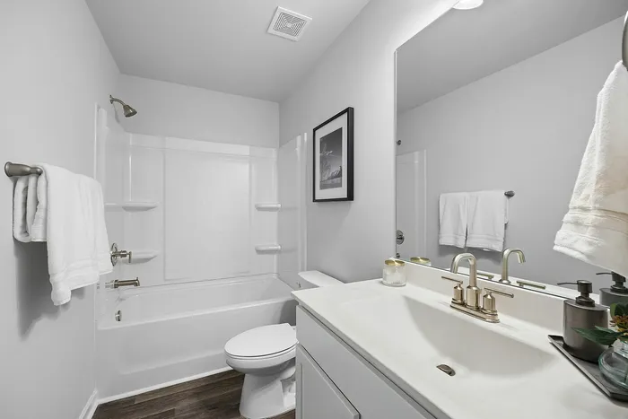 Modern and pristine bathroom featuring a sleek white sink, elegant fixtures, and a relaxing bathtub in a serene, neutral palette.