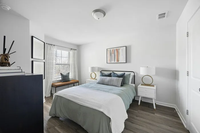 Bright and modern bedroom with elegant decor, featuring a cozy bed, stylish mirrors, and large window allowing natural light to fill the space.