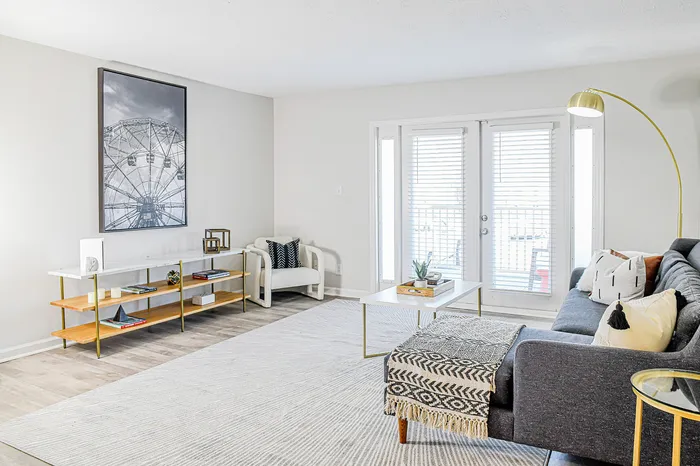 Bright and airy living room with modern decor, cozy sofa, and large windows offering abundant natural light.