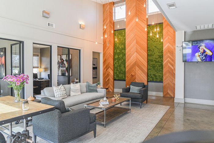 Modern lounge area with stylish seating, vibrant decor, and elegant pendant lighting, perfect for relaxation or entertaining guests.