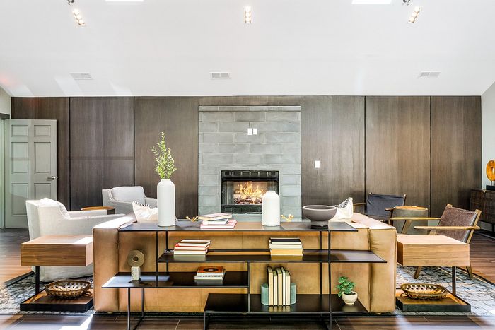 Chic living room with modern decor, featuring a cozy fireplace, sleek wooden shelving, and stylish seating arrangements.