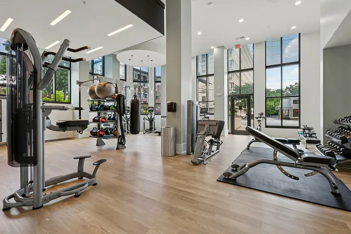 Elegant fitness center with modern exercise equipment, large windows, and ample natural light for a refreshing workout experience.