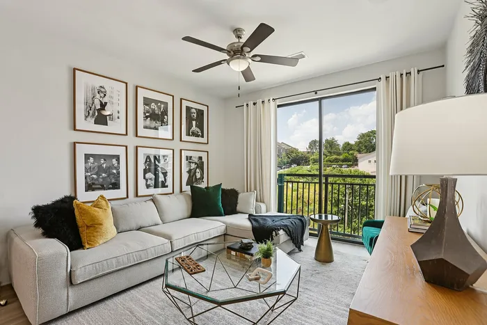 Chic and cozy living room with elegant decor, plush sectional sofa, and stunning balcony view.