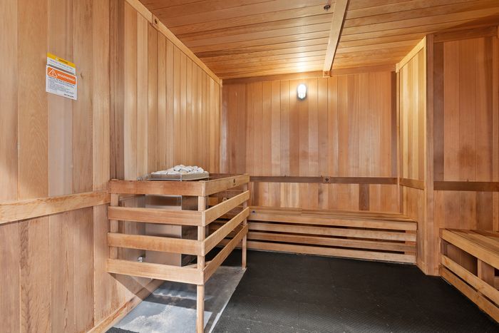Warm and inviting sauna room with sleek wood paneling and comfortable bench seating.