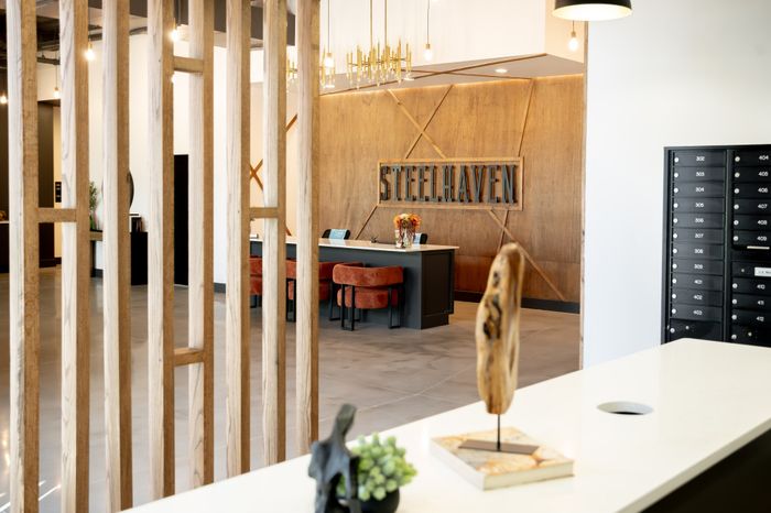 Elegant lobby of SteelHaven with rich wood accents, contemporary lighting, and stylish seating.