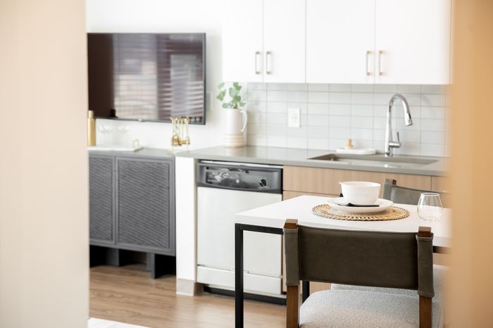 Chic modern kitchen with sleek cabinetry, stainless steel appliances, and a cozy dining area accentuated by elegant decor.