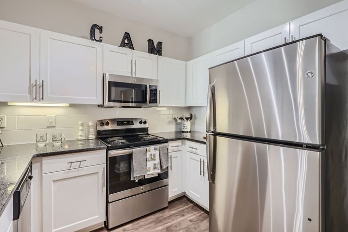 Contemporary kitchen featuring stainless steel appliances, sleek white cabinetry, and elegant countertops.