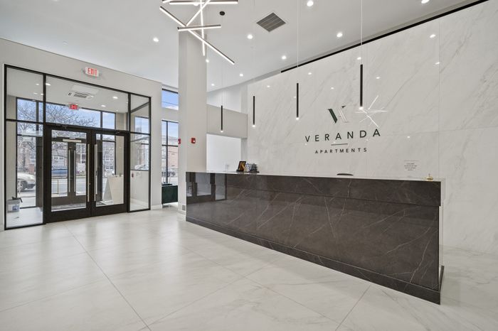 Spacious and modern lobby with sleek marble reception desk at Veranda Apartments.