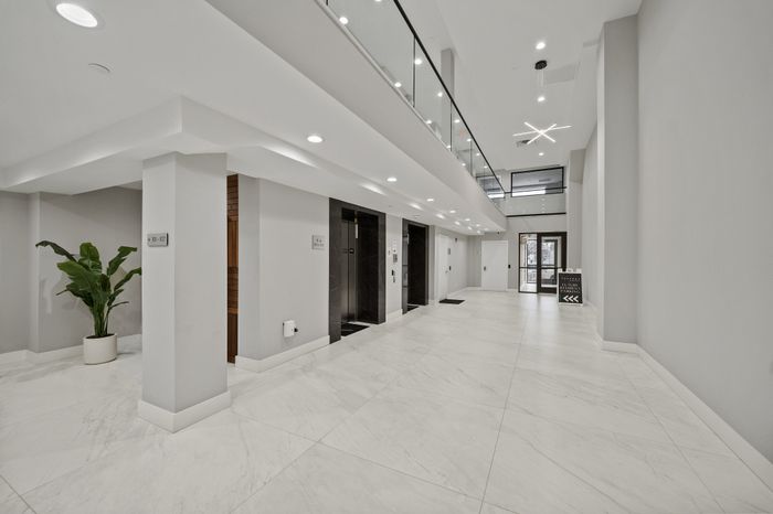 Elegant lobby with modern elevators, glossy marble floors, and stylish lighting.