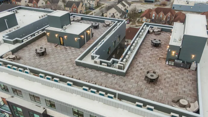 Expansive rooftop terrace with modern seating and lighting, offering a stunning view of the surrounding neighborhood.