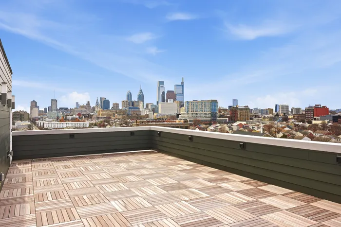 Luxurious rooftop terrace with stunning city skyline views and elegant wood flooring.