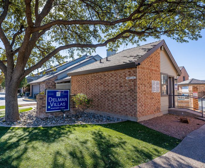 Charming Delmar Villas office entrance surrounded by lush greenery and inviting pathways, highlighting a welcoming community atmosphere.