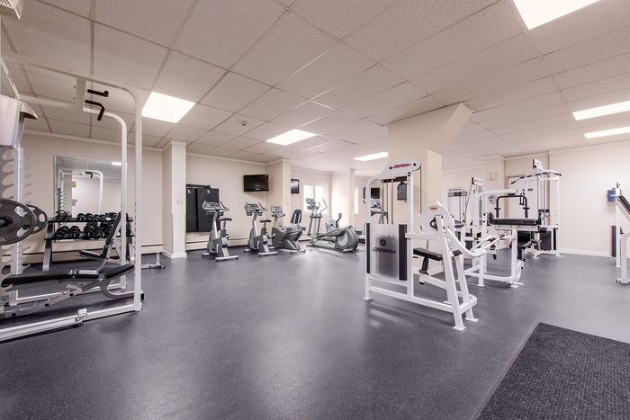 Modern fitness center with state-of-the-art equipment, ample natural light, and spacious workout areas.