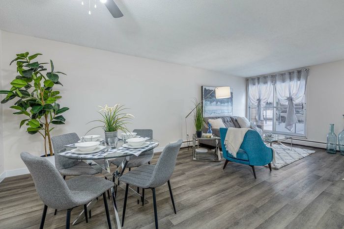 Bright, modern apartment with an open-concept living and dining area, featuring elegant decor, stylish furnishings, and large windows.