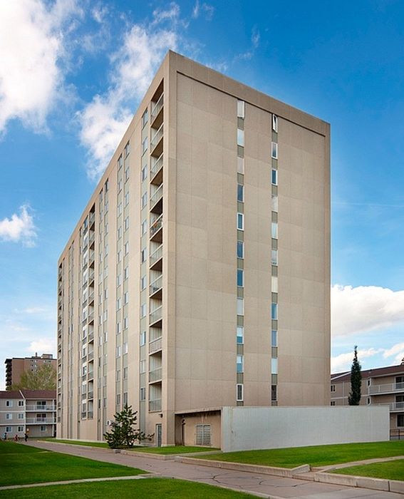Elegant high-rise apartment building with modern design, set against a clear blue sky, offering urban living with scenic views.