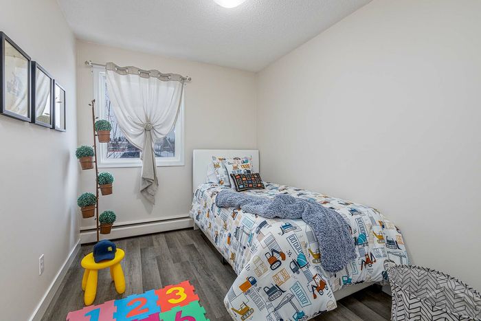 Charming children's bedroom featuring a cozy bed with playful bedding, vibrant decor, and a window view that fills the room with natural light.