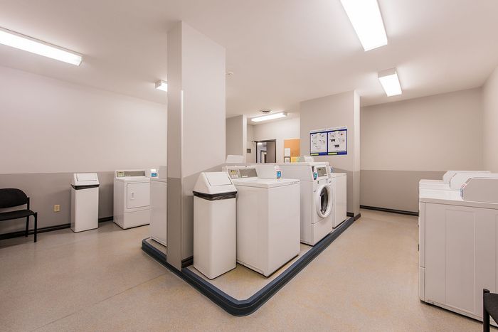 Bright and modern laundry room with multiple washers and dryers, perfect for convenient and efficient living.
