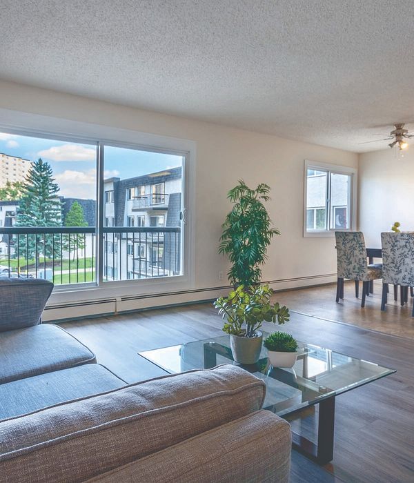 Bright and airy living room with modern decor, large windows, and open dining area, offering a cozy and inviting ambiance.