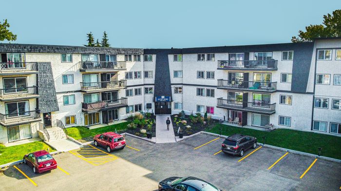 Charming apartment complex with modern balconies, lush landscaping, and convenient parking nestled in a serene neighborhood.