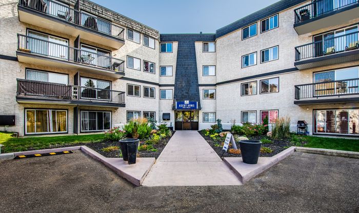 Charming apartment complex with modern balconies and beautifully landscaped entrance, offering a welcoming and stylish living environment.