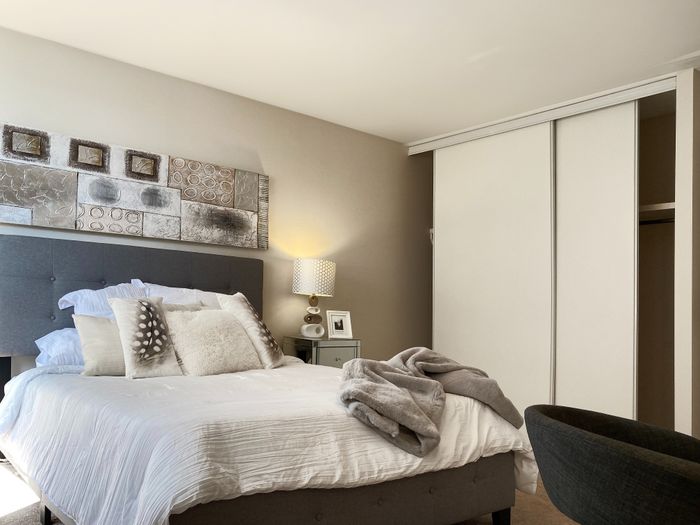 Inviting bedroom with a plush bed, elegant decor, and soft lighting for a cozy ambiance.