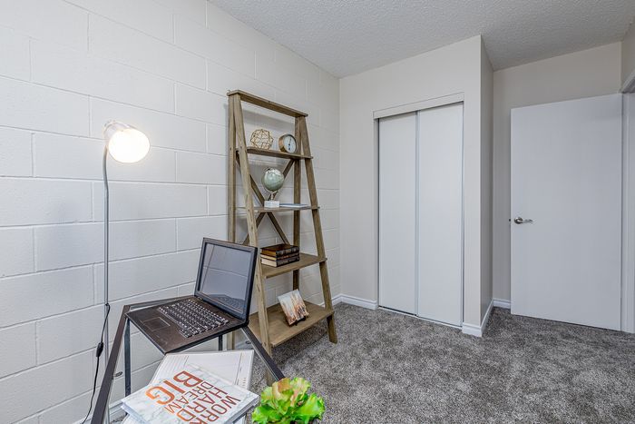 Cozy home office with a modern floor lamp, sleek desk, and a rustic ladder bookshelf.