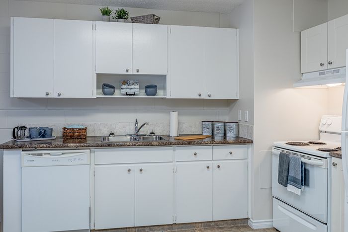 Inviting kitchen with sleek white cabinetry, modern appliances, and a cozy countertop, creating a perfect blend of functionality and style.