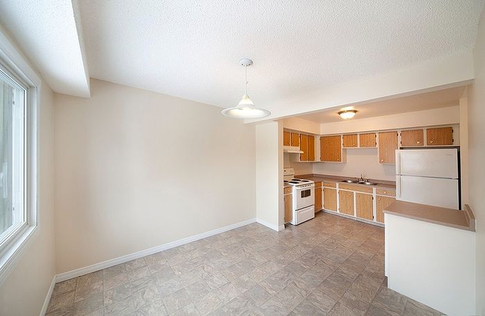 Bright and inviting kitchen and dining area featuring modern appliances, ample counter space, and large windows in a spacious open layout.