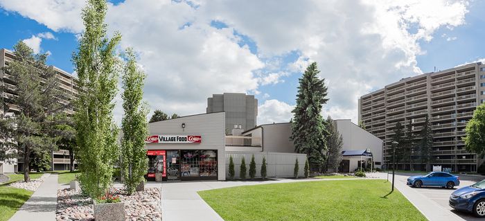 Charming urban apartment complex with modern architecture and lush landscaping, featuring a nearby convenience store for easy access to essentials. Ideal for comfortable city living.