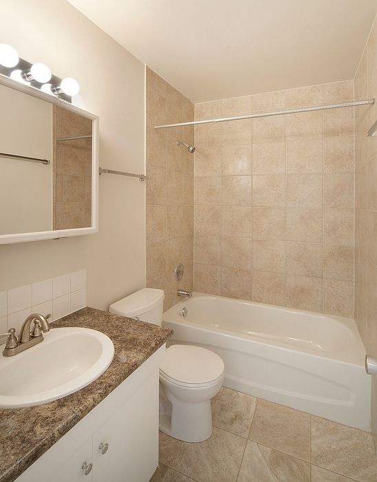 Inviting bathroom with a modern vanity, elegant tile, and a spacious bathtub.