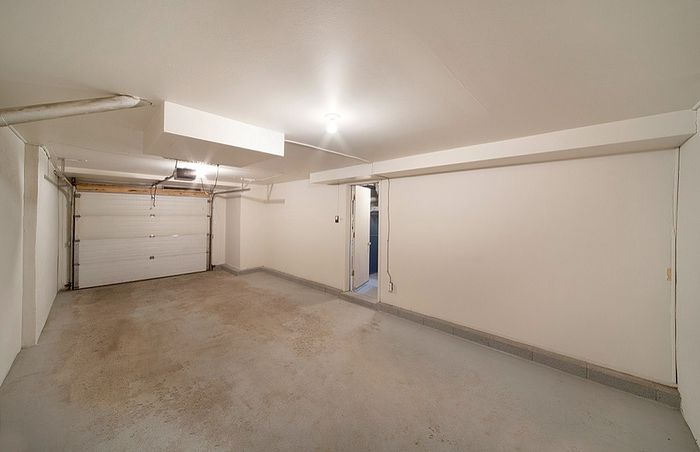 Spacious and versatile garage with clean white walls and ample lighting, perfect for storage or workshop potential.