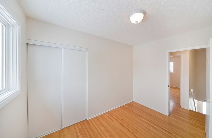 Bright and airy room with sleek hardwood flooring and a large sliding closet, perfect for a modern living space.
