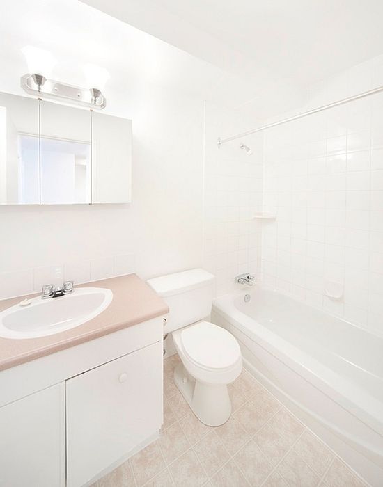 Bright and modern bathroom featuring a sleek sink, pristine bathtub, and elegant tile flooring.