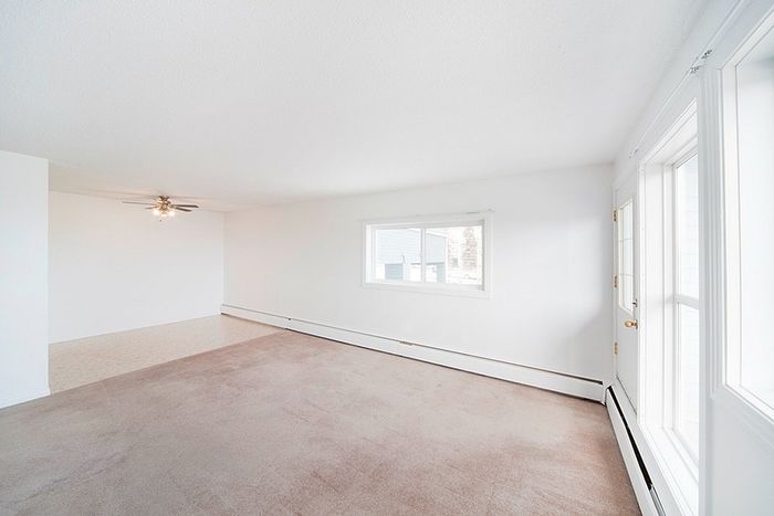 Bright and airy living room with plush carpet and large windows offering abundant natural light.
