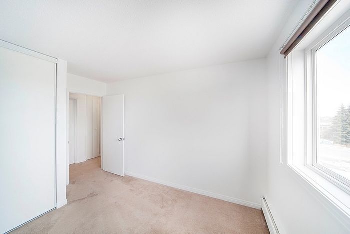 Bright and inviting room with a large window offering abundant natural light, perfect for a cozy bedroom or office space.