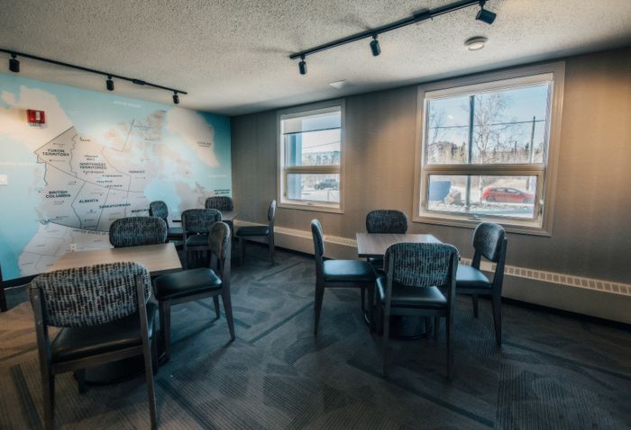 Cozy dining area with contemporary seating and a large world map mural, perfect for social gatherings or studying.