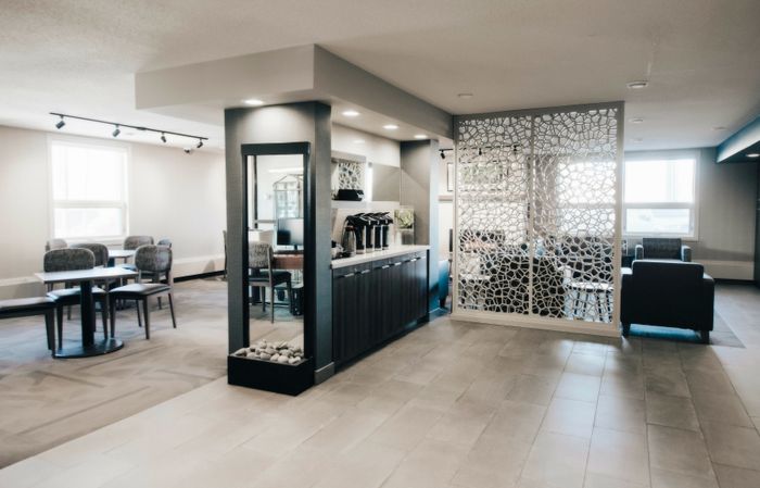 Elegant apartment common area with modern seating, stylish partition, and sleek coffee station, perfect for socializing and relaxation.