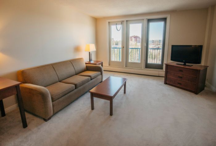 Bright and inviting living room with comfortable sofa, stylish coffee table, and large windows offering scenic views.