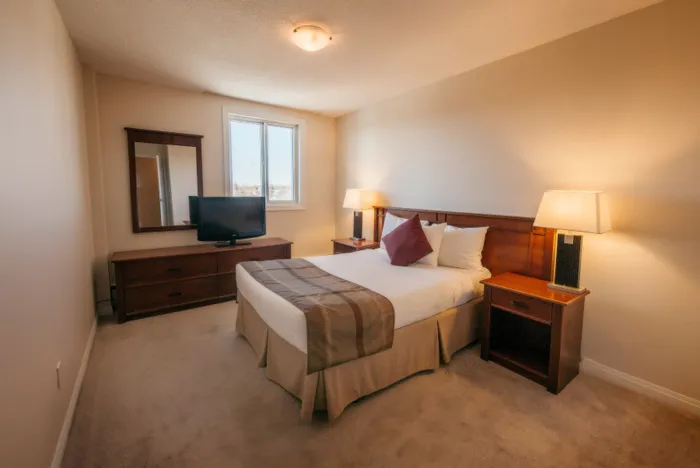 Inviting bedroom with cozy double bed, elegant wooden furniture, and soft lighting creating a warm ambiance.