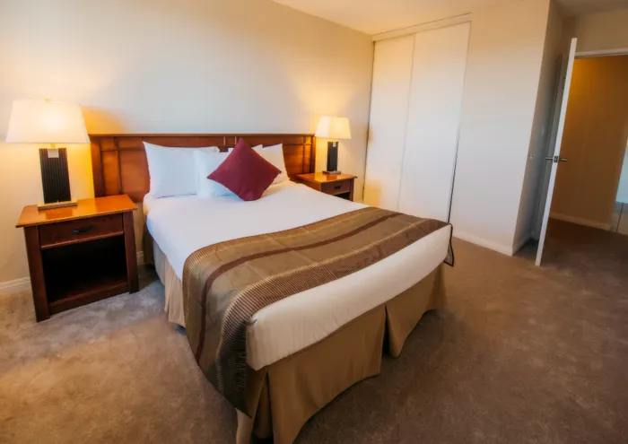 Inviting bedroom with a cozy double bed, elegant wooden headboard, and soft ambient lighting.