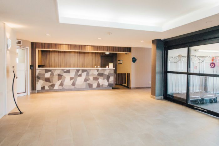 Welcoming lobby area with modern geometric design, featuring a spacious reception desk and stylish decor.