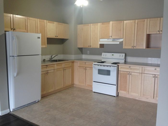 Modern kitchen with light wood cabinets, white appliances, and ample counter space, offering a bright and functional cooking environment.