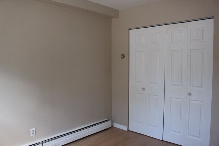 Bright and welcoming room with a modern beige wall and elegant white double doors, perfect for a cozy apartment setting.