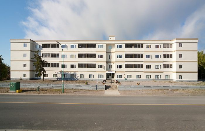 Charming four-story apartment building with multiple windows, offering ample natural light and modern living spaces.