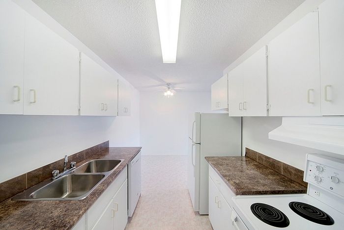 Bright and spacious kitchen with modern white cabinetry, sleek countertops, and a contemporary stove setup.