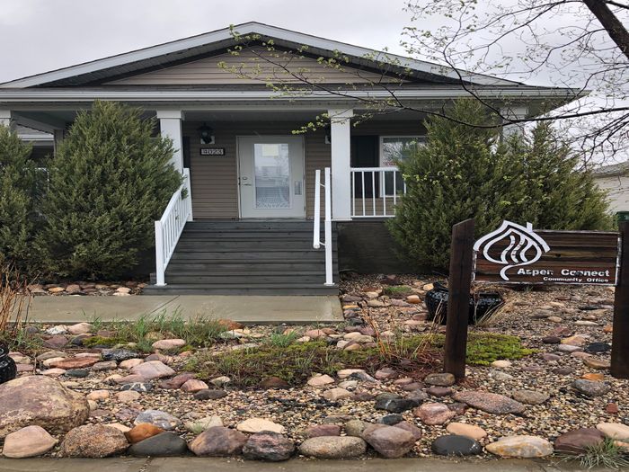 Charming front view of a cozy bungalow with a welcoming porch and beautifully landscaped garden featuring natural stone elements.