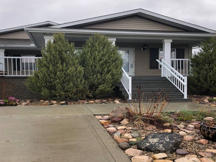 Charming single-story home with welcoming front porch, manicured landscaping, and stone pathway.