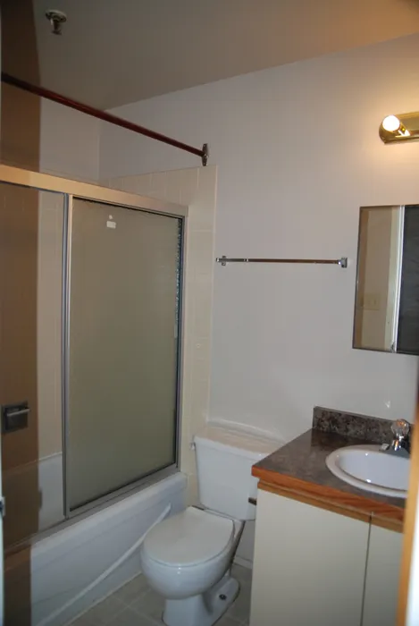 Charming bathroom with a sleek glass shower, modern lighting, and a stylish countertop.